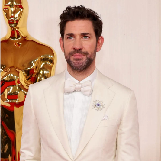 Vintage broche in goud met edelstenen gedragen op blazer – moderne styling van klassiek juweel